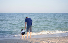 Vater und Sohn spazieren am Strand 