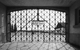 schwarz-weiß-Aufnahme Tor des Konzentrationslager Dachau mit der Aufschrift "Arbeit macht frei"